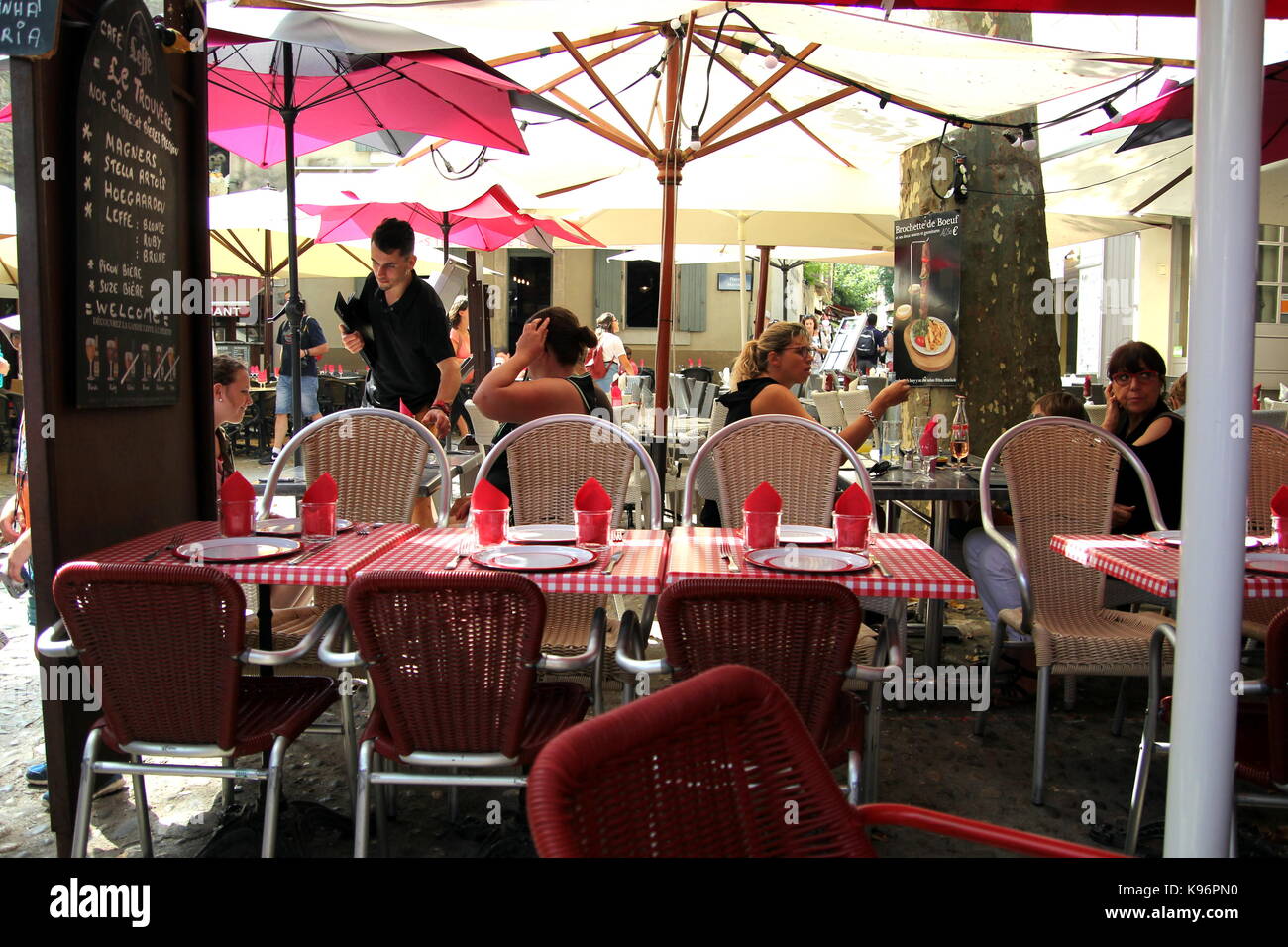 Kellner bedienen von Kunden genießen die Schatten in einem kleinen Straßencafe in Südfrankreich Stockfoto