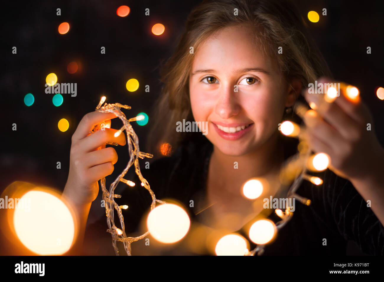 Schöne Mädchen im Teenageralter Holding festliche Weihnachtsbeleuchtung Stockfoto