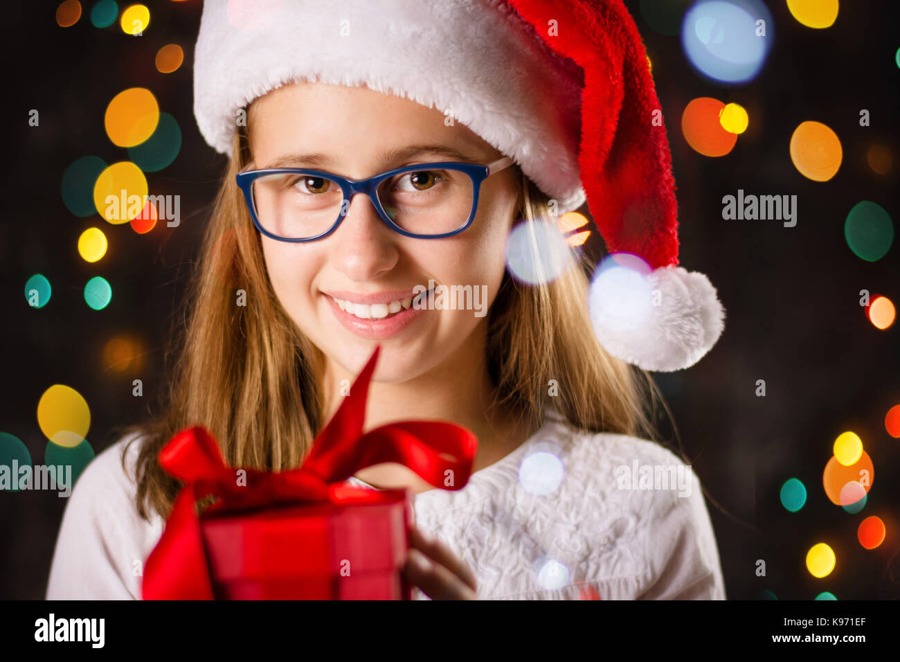 Junges Mädchen mit Weihnachtsmütze Holding ein Geschenk Box Stockfoto