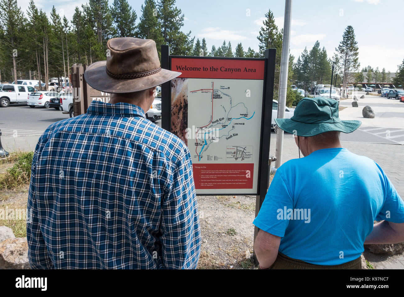 Zwei ältere Männer, tragen Hüte, betrachten die veröffentlicht Brett/Karte der Canyon village Bereich direkt vor dem Besucherzentrum Yellowstone National Park Stockfoto