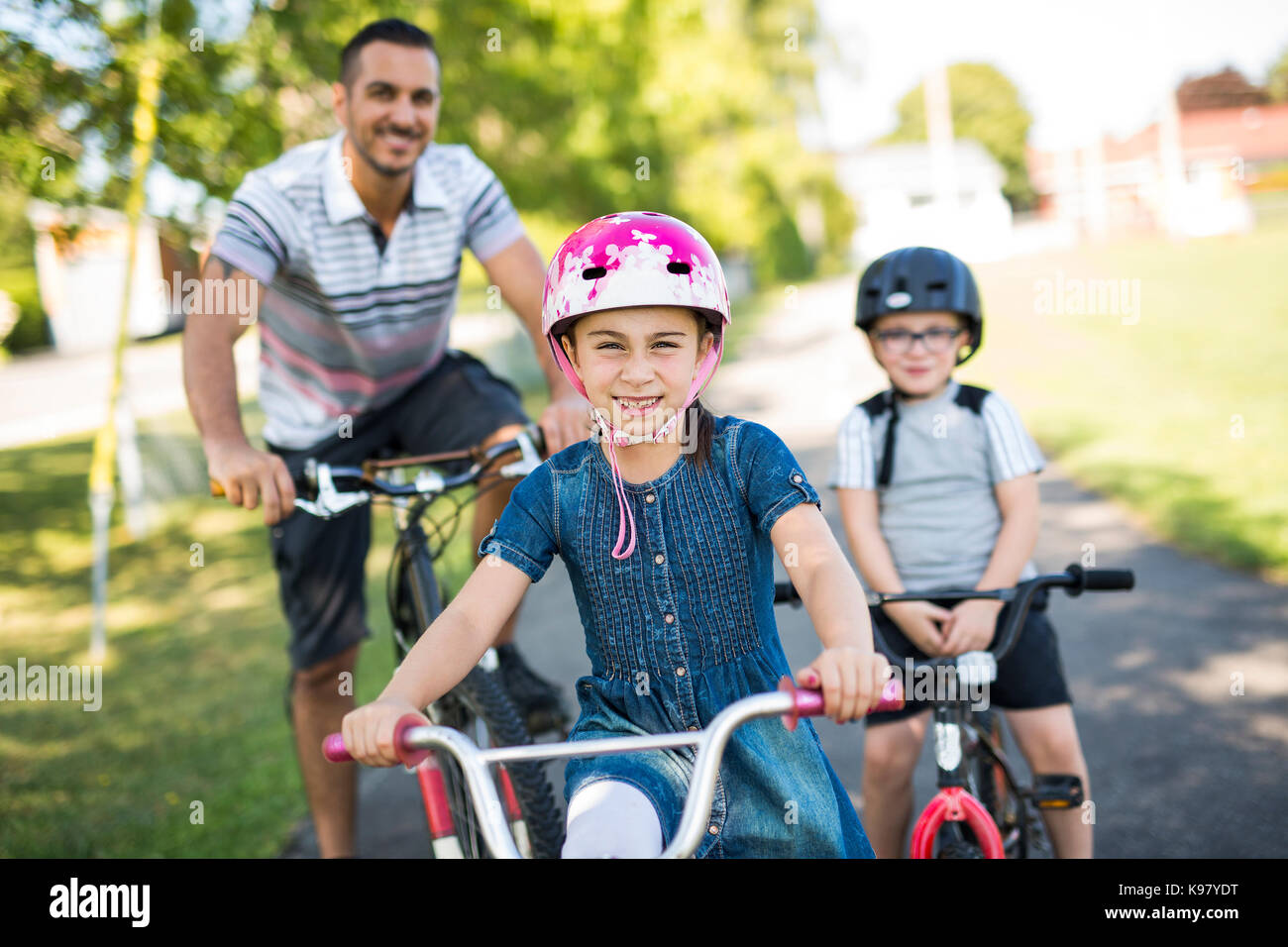 Vater mit Tochter Sohn Fahrrad im Park Stockfoto