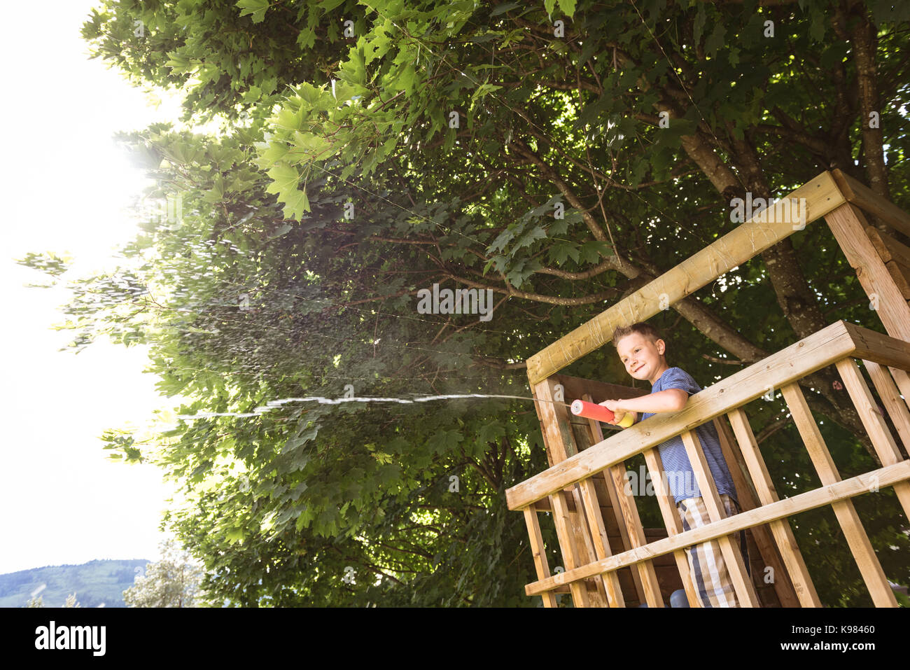 Süße Junge spielt mit wasser Gewehr in Spielplatz Stockfoto