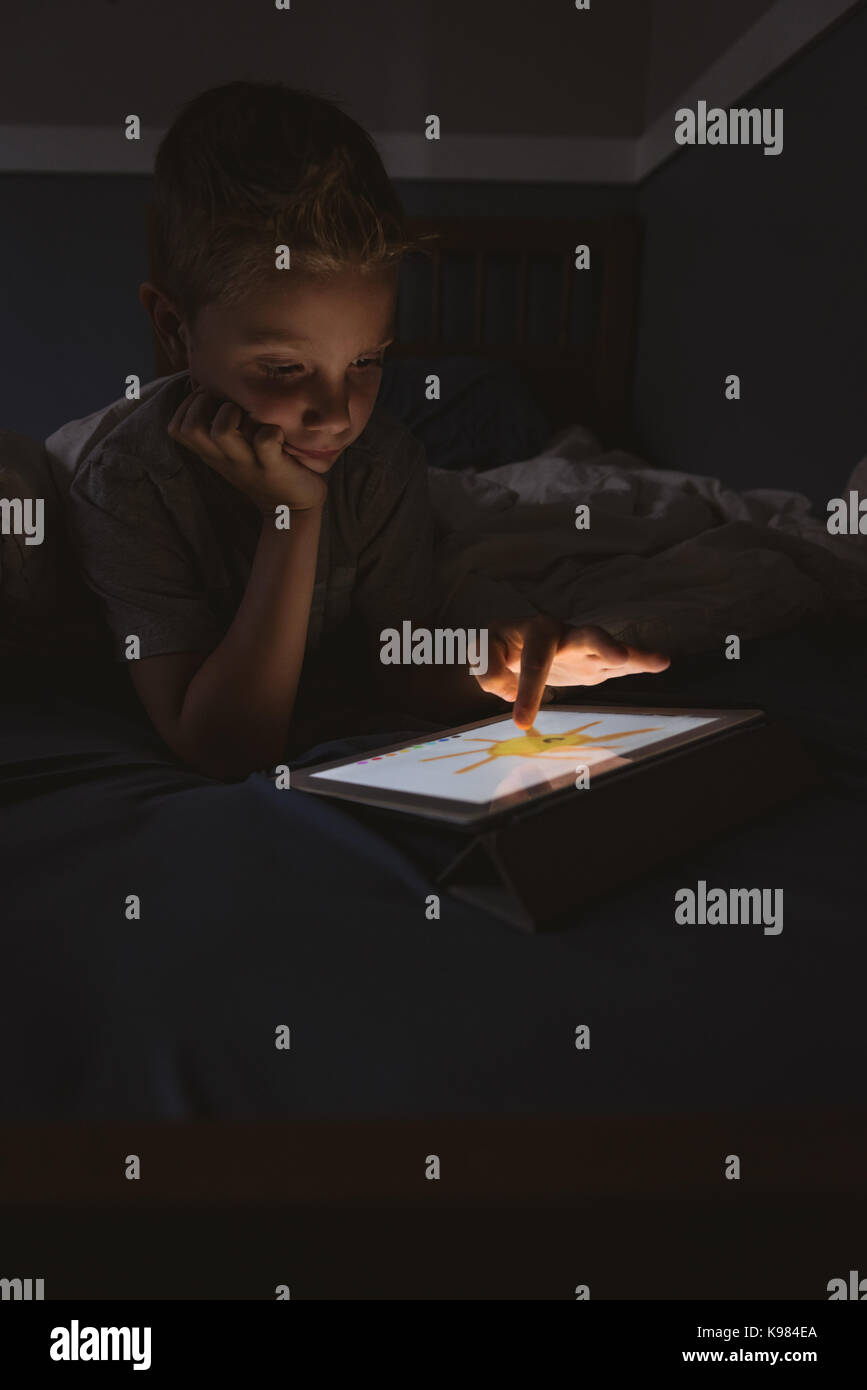 Cute Boy mit digitalen Tablet im Schlafzimmer Stockfoto