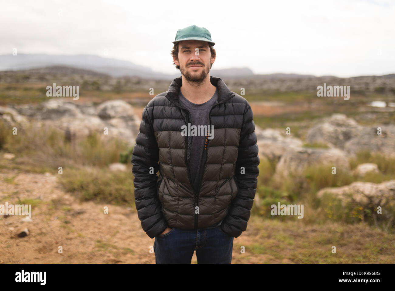 Portrait von zuversichtlich Mann stand mit den Händen in den Taschen Stockfoto