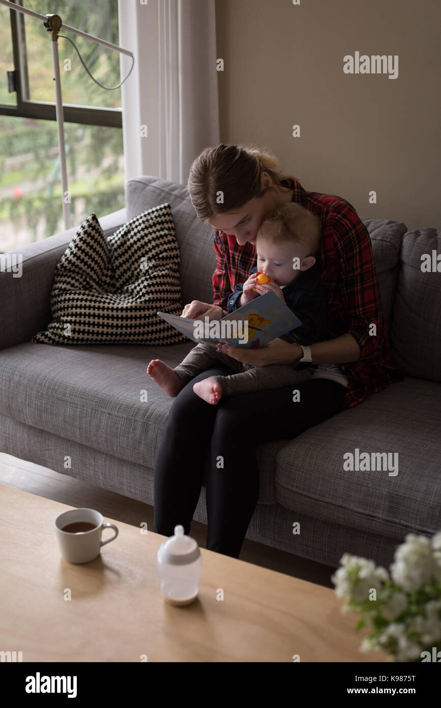 Hohe Betrachtungswinkel von Mutter zeigt Bild Buch zum Sohn beim Sitzen auf dem Sofa zu Hause Stockfoto
