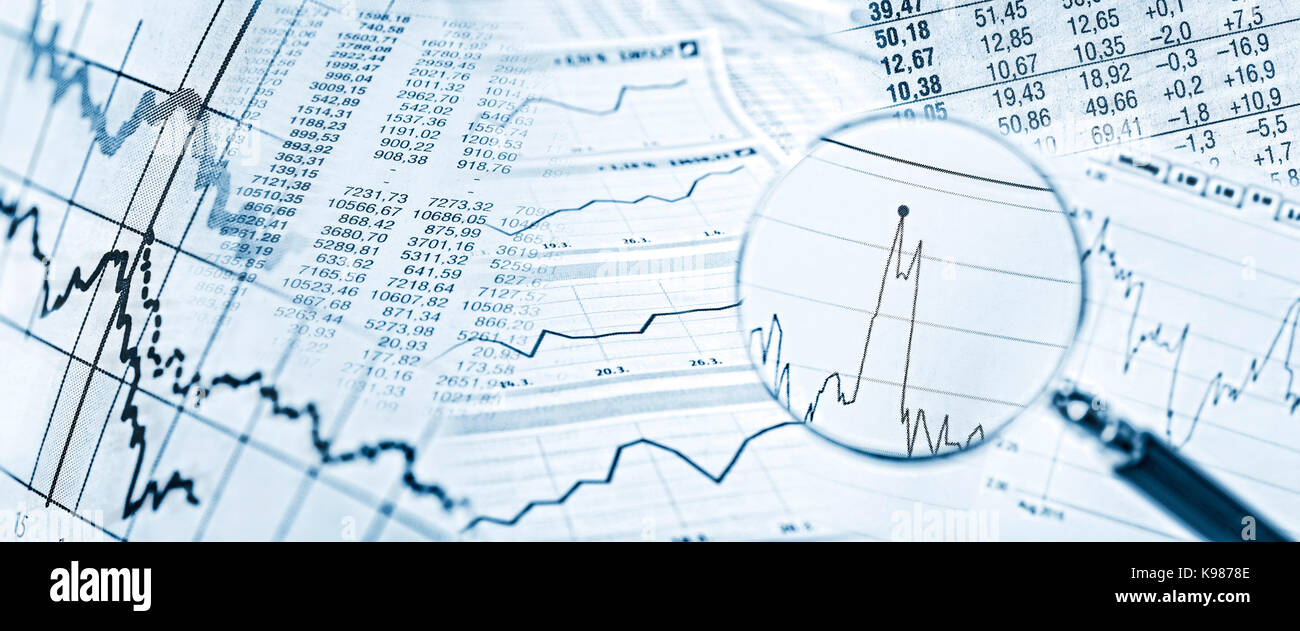 Aktienkurse, Charts und eine Lupe mit Aktienpreis im Detail. Stockfoto