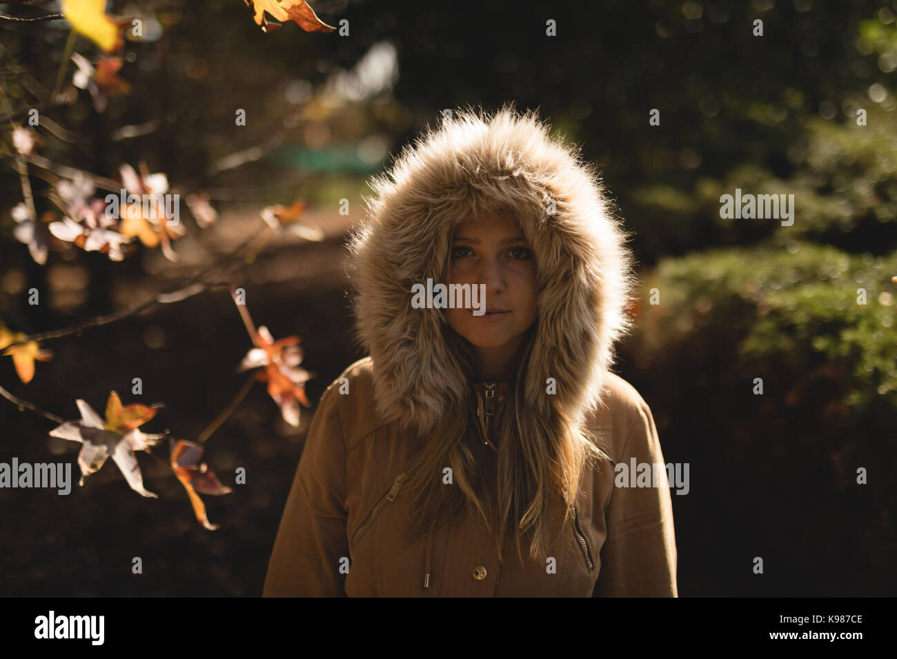 Porträt der jungen Frau Wintermantel im Park im Herbst Stockfoto