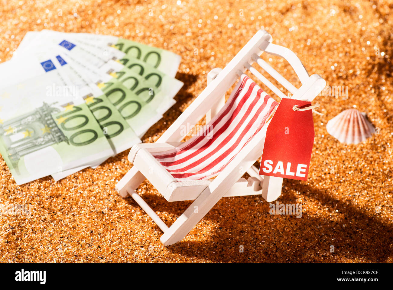 Liegestuhl am Strand, Rabatt Label mit dem Wort Verkauf und Banknoten Stockfoto