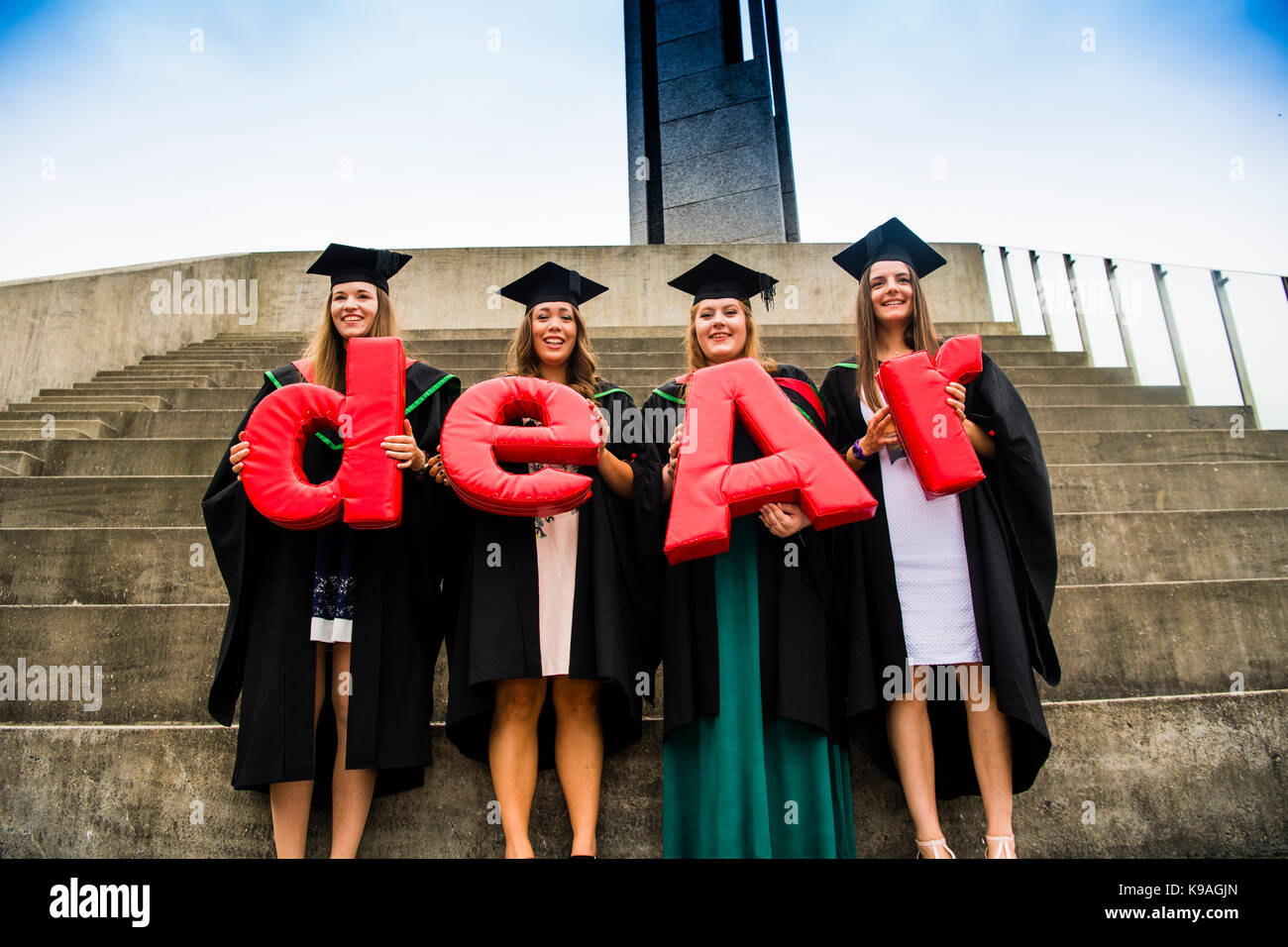 Die Kosten der Hochschulbildung im Vereinigten Königreich: Aberystwyth Studenten tragen traditionelle akademische Kittel und Mörtel Platten-Holding die Buchstaben aber das Wort "Ohr" auf Ihrer Abschlussfeier zu bilden, Juli 2017 Stockfoto