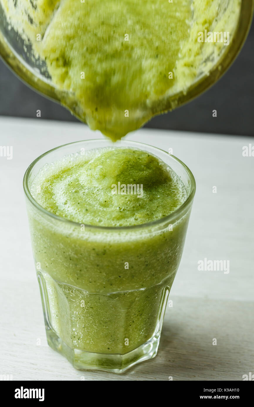 Gießen Sie Gemüsesmoothie in ein Glas Stockfoto
