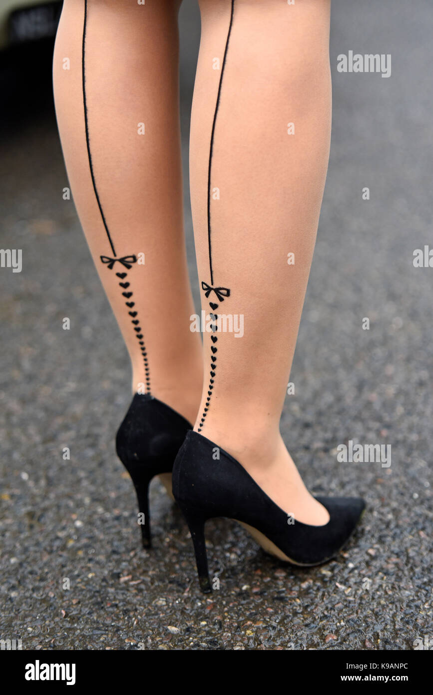 Weibliche Beine in Herz- und Bugnylonen beim Goodwood Revival 2017. Mode Stockfoto