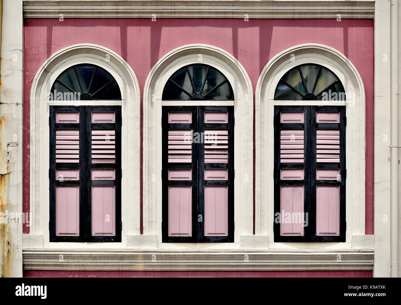 Traditionelle Singapur shop Haus außen mit rosa Fassade, Bogenfenster und Rosa hölzerne Lamellenfensterläden im historischen Duxton Bezirk. Stockfoto