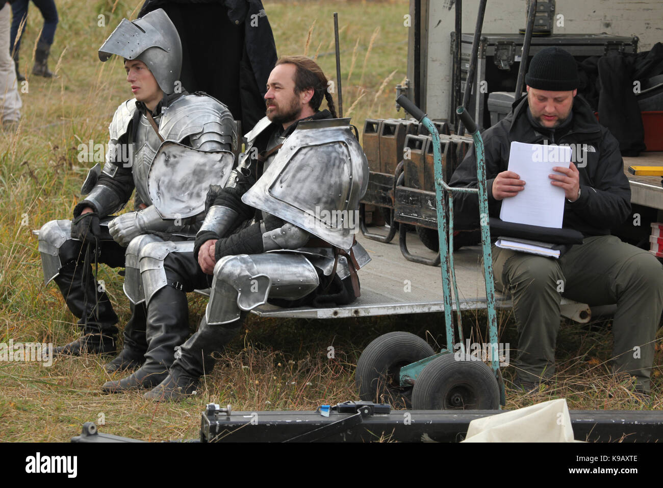 Der tschechischen Schauspieler Michal Bednář (L) und einem unbekannten Schauspieler verkleidet als mittelalterliche Ritter im Backstage neben den Mitarbeiter während der Dreharbeiten des Neuen Deutschen Films 'Die Ritter" ("Die Ritter") unter der Regie von Carsten Gutschmidt im Auftrag des ZDF, in Milovice in Südböhmen, Tschechische Republik, 23. Oktober 2013. Stockfoto