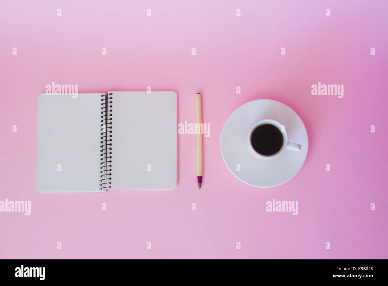 Blick von oben auf die leeren Notizbuch, Stift und Tasse Kaffee über rosa Hintergrund. Stockfoto
