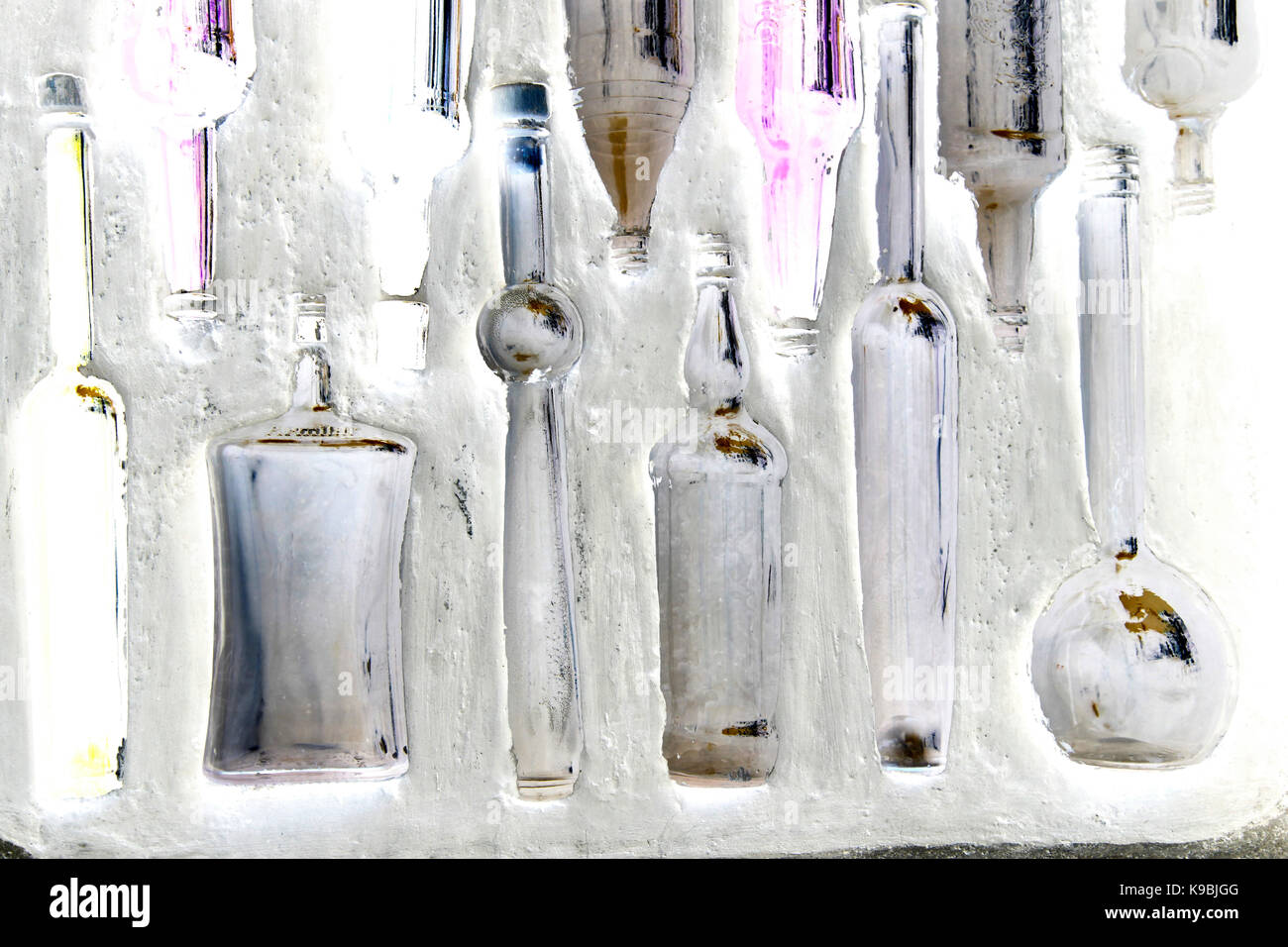Flaschen in einer Wand - Glasflaschen eingebettet in einer weiß getünchten Wand Stockfoto