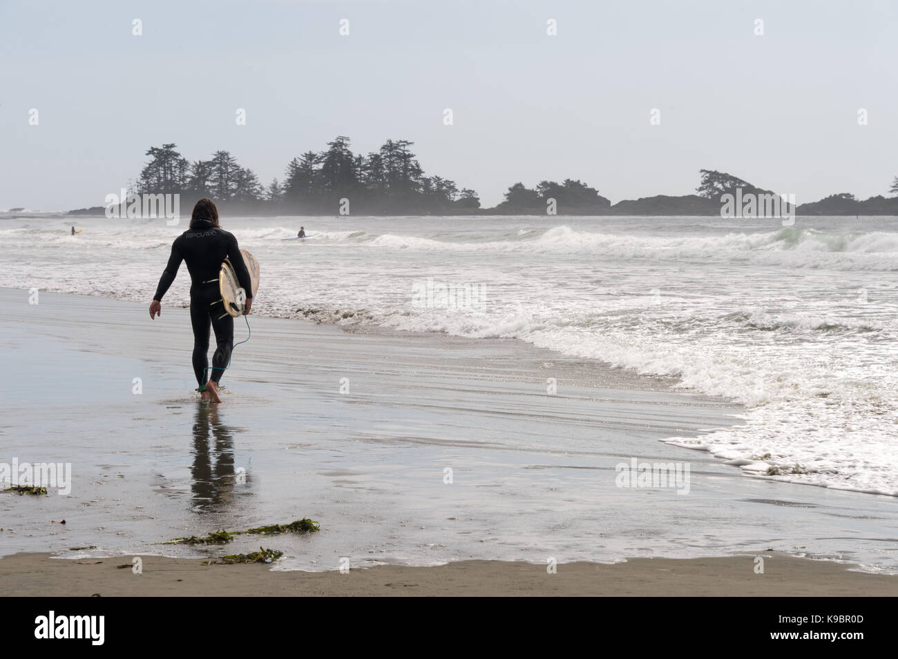 Tofino, Britisch-Kolumbien, Kanada - 9 September 2017: Surfer holding Surfbretter auf Chesterman Beach Stockfoto