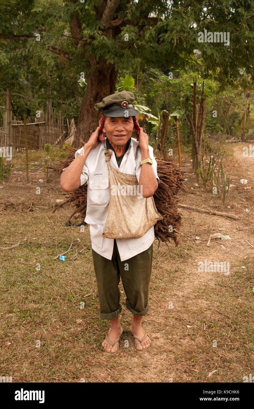 Porträt eines alten Laotischen Soldaten tragen seiner alten Army Cap mit Holz aus dem Wald im Norden und Osten Laos Stockfoto
