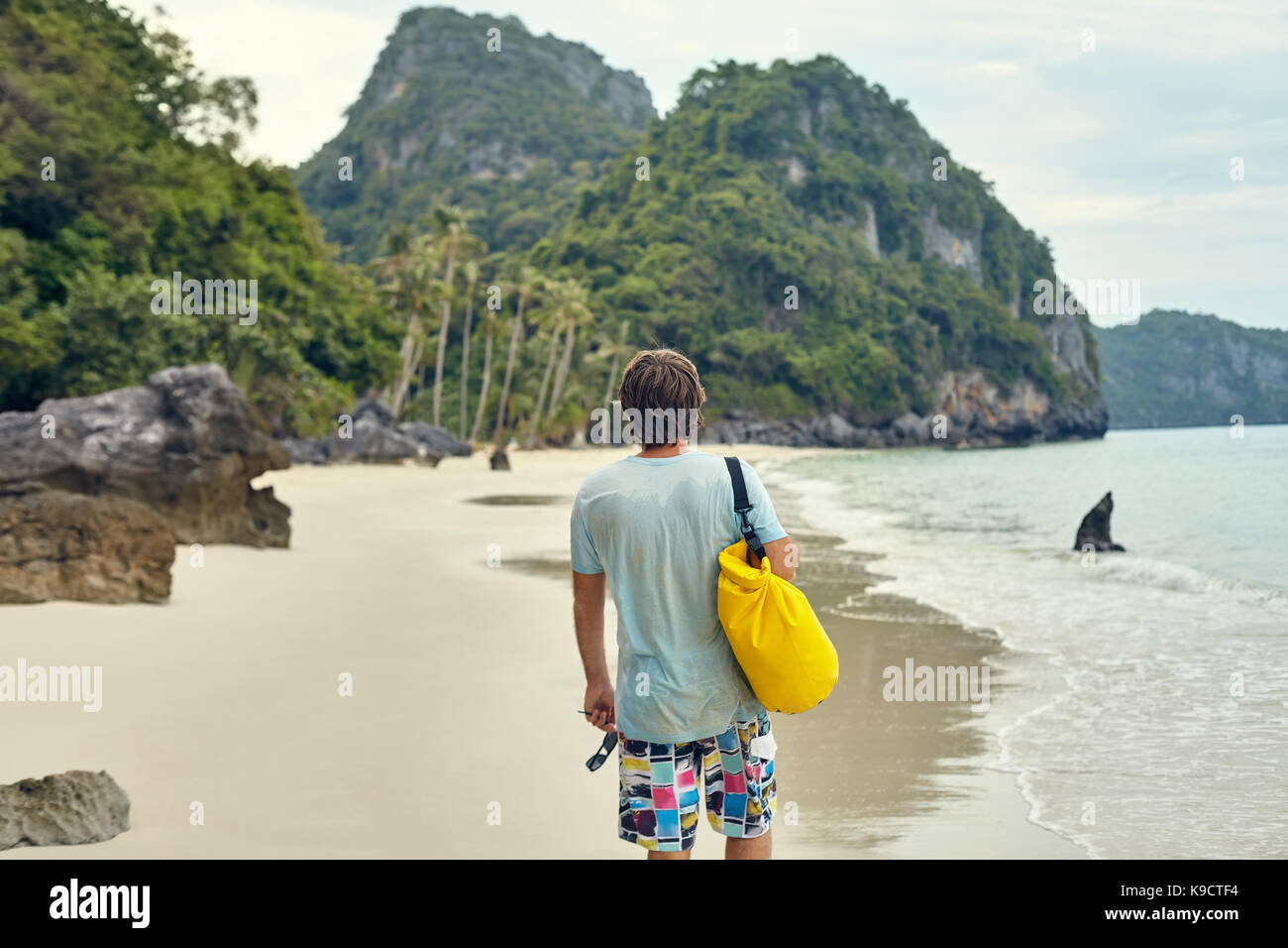 Junge touristische Mann mit Rucksack zu Fuß auf tropischen Strand Stockfoto