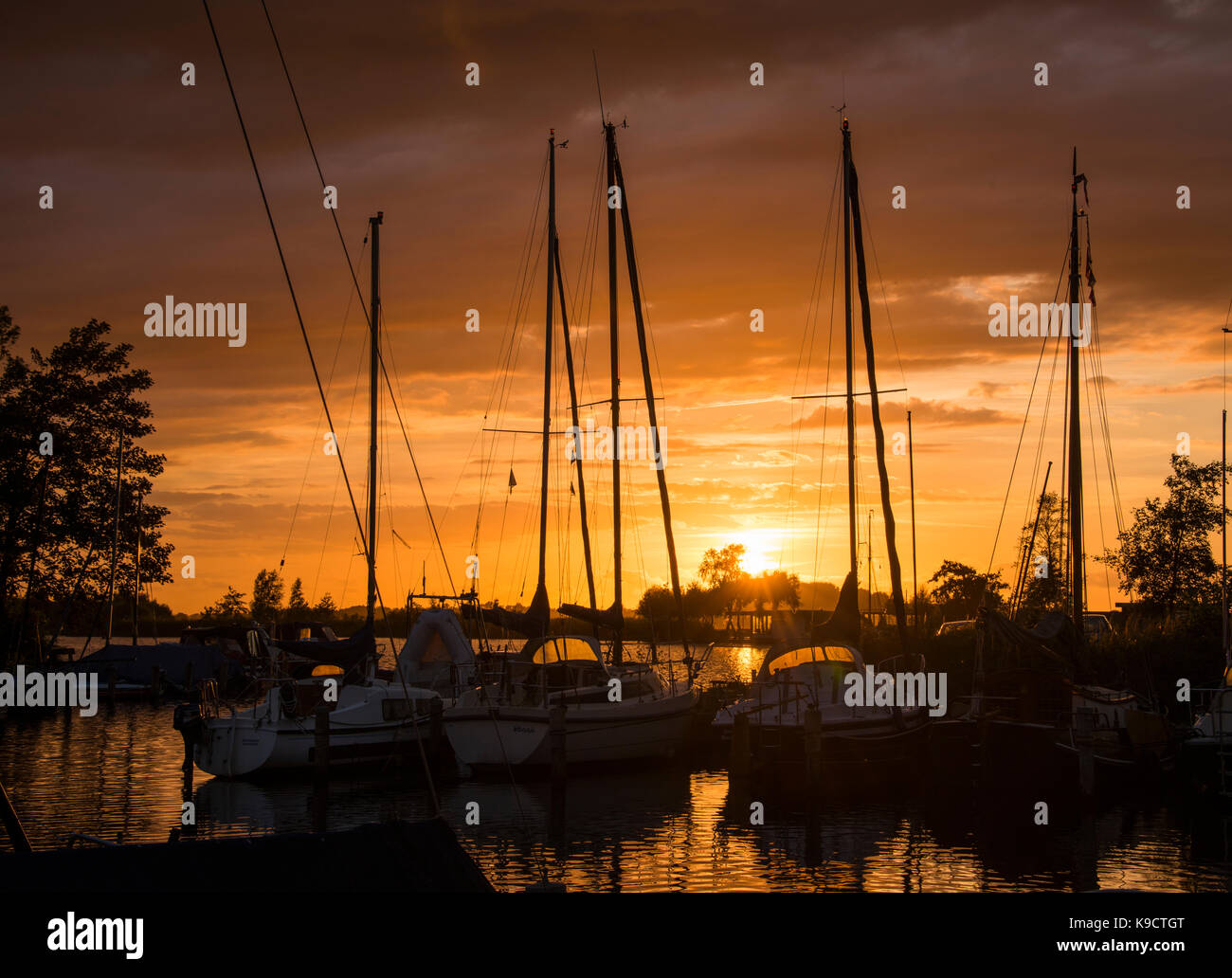 Sonnenuntergang im Hafen von De veenhoop in frieland hollandwith in Rot und Orange Stockfoto