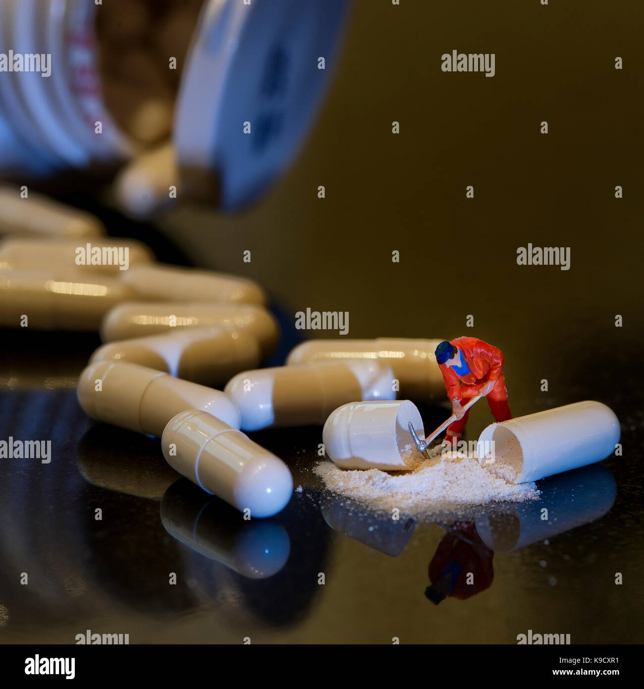 "Ein harter Tag an der Pille Factory"-Mann mit Pick-axe und weißes Pulver verschüttet heraus - Flasche und andere Pillen unscharf im Hintergrund Stockfoto