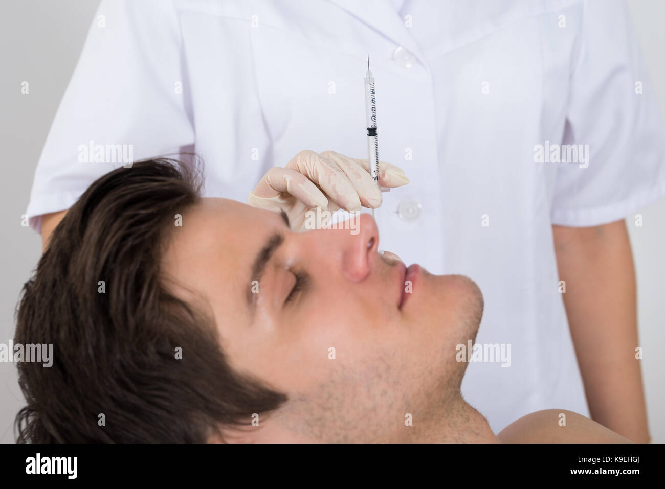 Close-up des Menschen, Faltenbehandlung vom weiblichen Arzt Holding Spritze Stockfoto