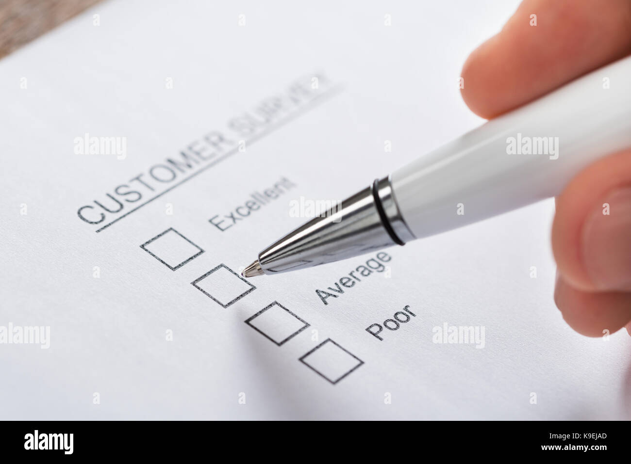 Nahaufnahme der Person Hände mit Kugelschreiber ausfüllen Kundenbefragung leeres Formular Stockfoto