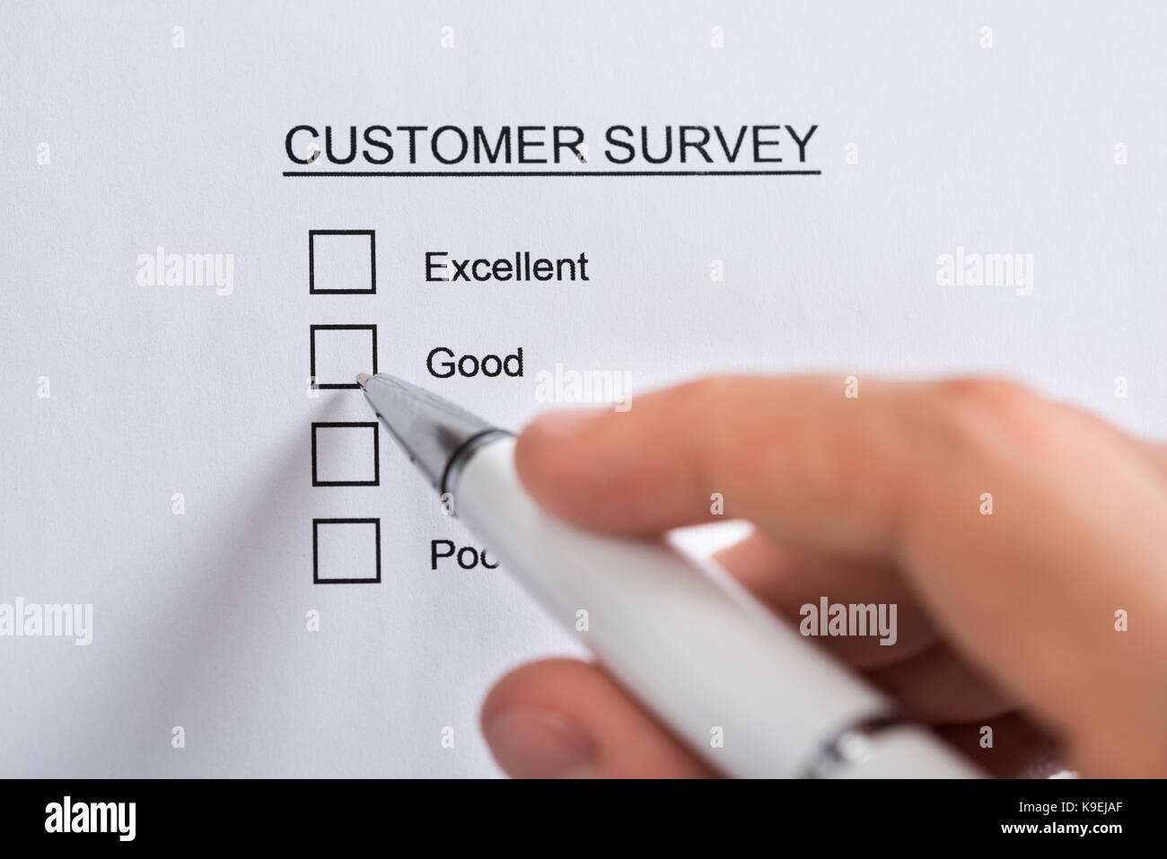 Nahaufnahme der Person Hände mit Kugelschreiber ausfüllen Kundenbefragung leeres Formular Stockfoto