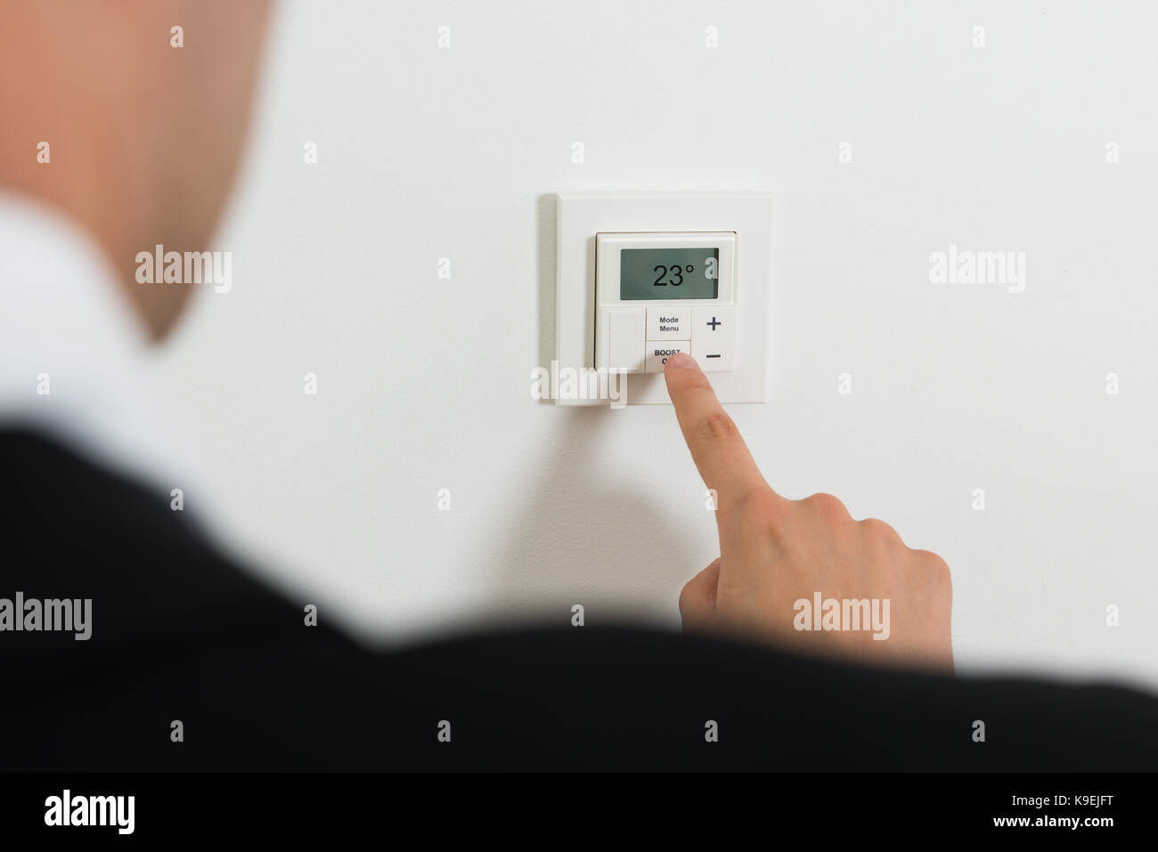 Nahaufnahme der Unternehmer Einstellung Temperatur auf Digitaler Thermostat an der Wand Stockfoto Nahaufnahme der Unternehmer Einstellung Temperatur auf Digitaler Thermostat an der Wand Stockfoto