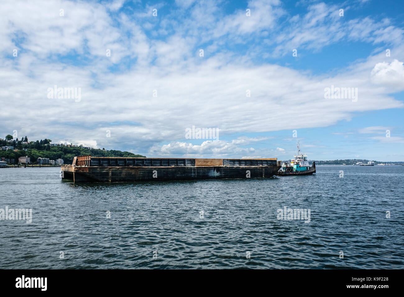 Ein Schubschiff zieht einen beladenen Lastkahn in Elliot Bay in der Nähe von West Seattle Stockfoto