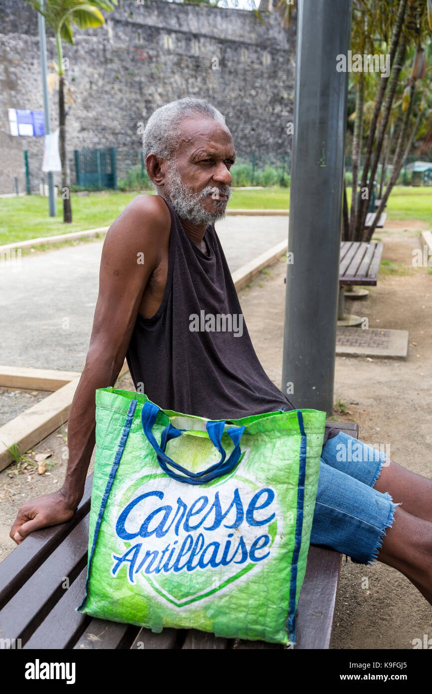 Fort-de-France, Martinique. Älterer Mann ruht auf einer Parkbank. Stockfoto