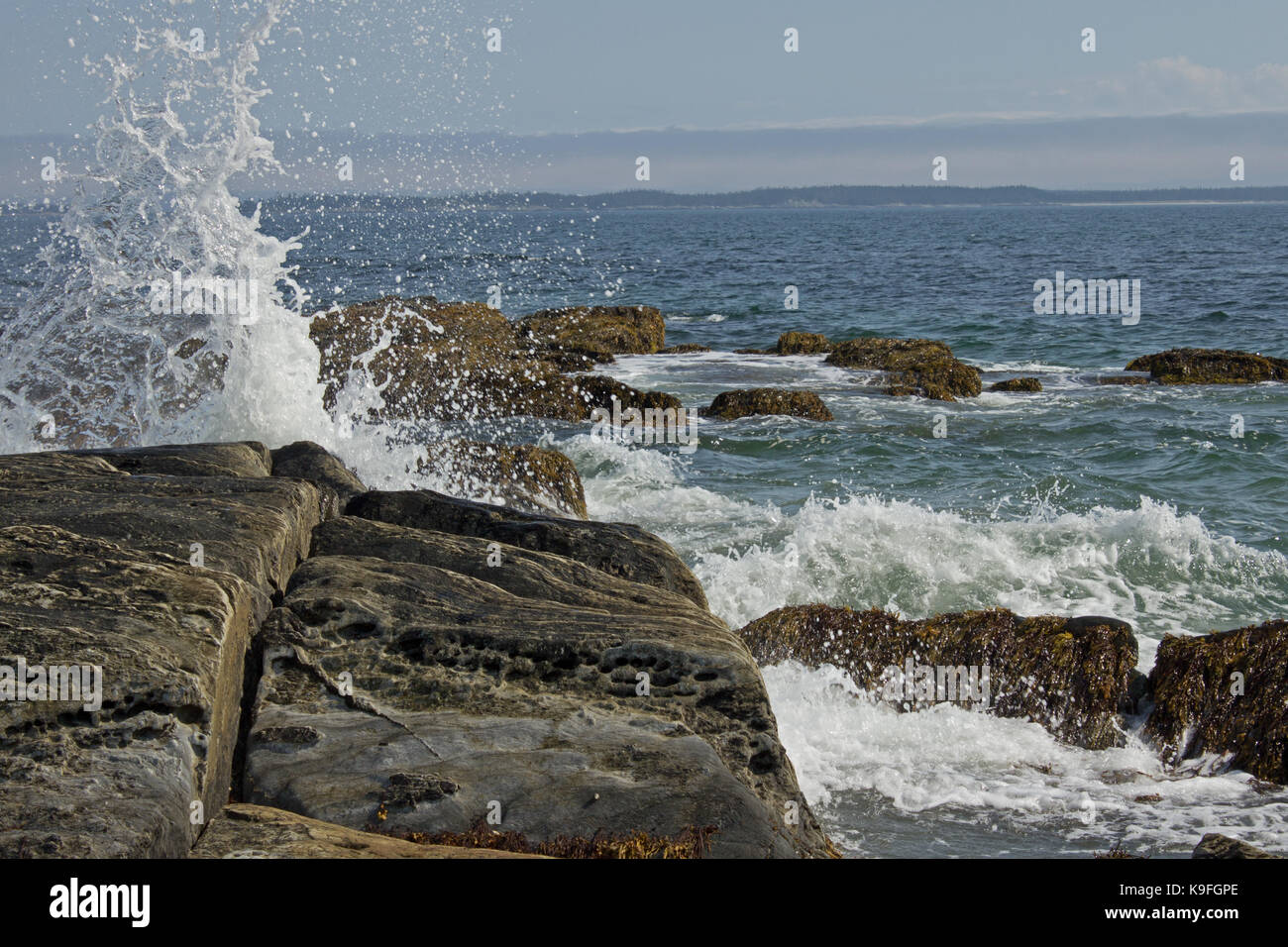 Ocean Spray und Surf Pfund gegen Felsen an der Küste Stockfoto