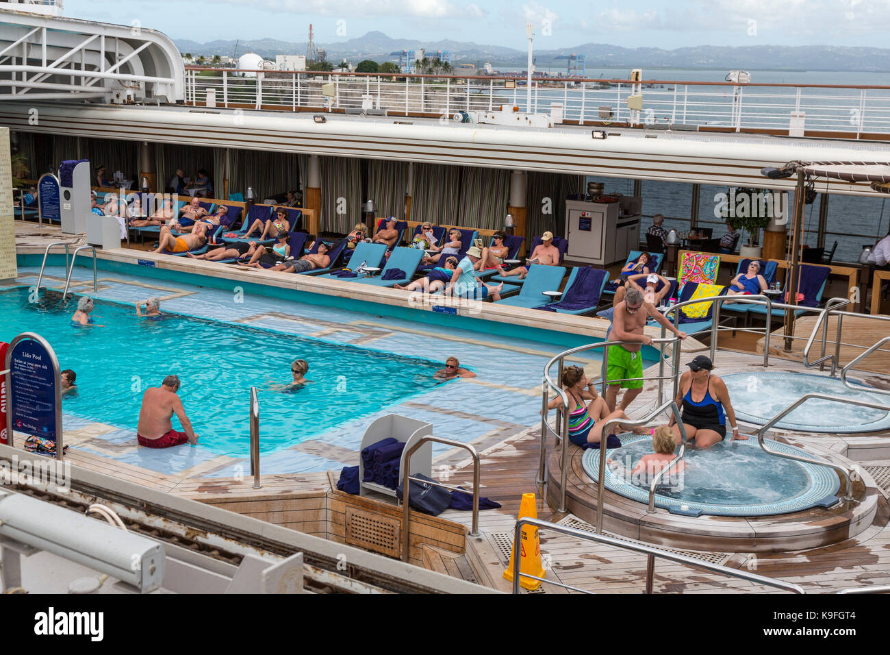 Karibik Kreuzfahrt Schiff Passagiere an Bord Entspannen rund um das Schwimmbad. Für die redaktionelle Verwendung. Stockfoto