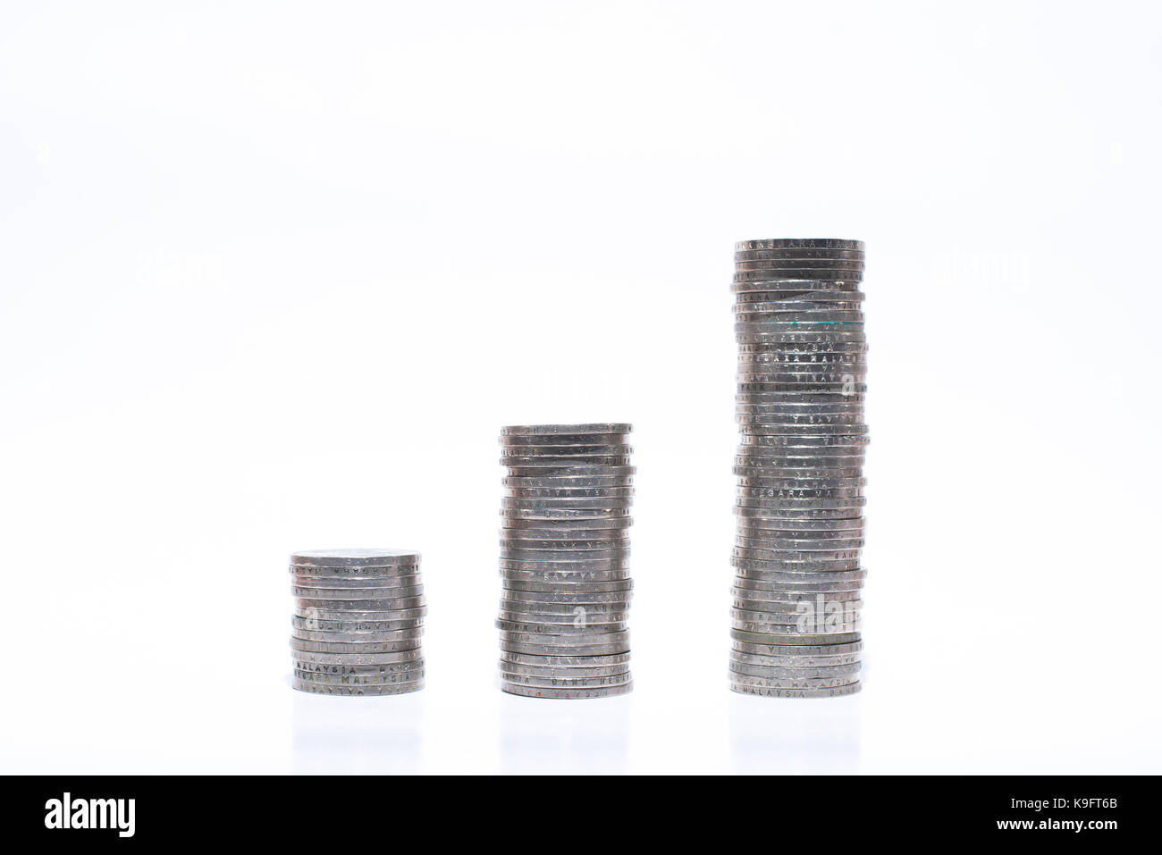 Gestapelte Münzen auf einem weißen Hintergrund. Das Finanzkonzept. Stockfoto