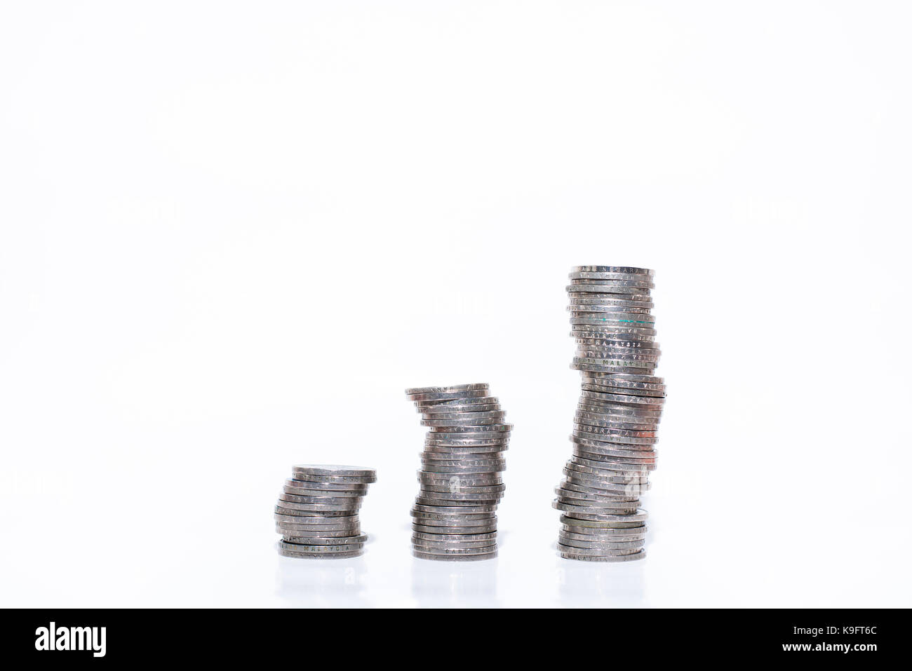 Gestapelte Münzen auf einem weißen Hintergrund. Das Finanzkonzept. Stockfoto