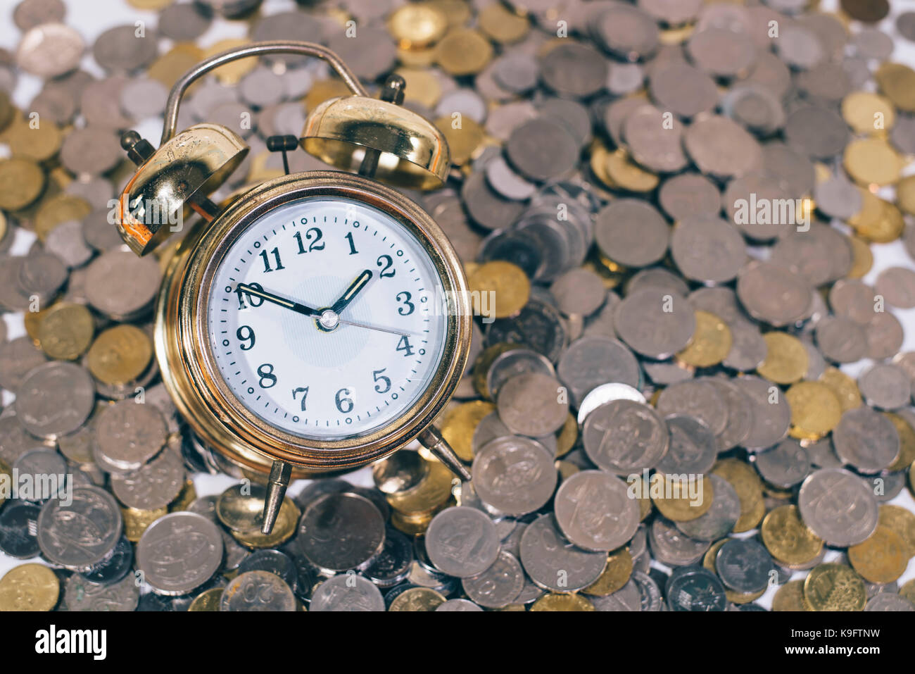 Golden Bell Uhr auf eine Gruppe von Münzen. Zeit ist Gold/geld-Konzept.  Malaysia Währung Stockfotografie - Alamy