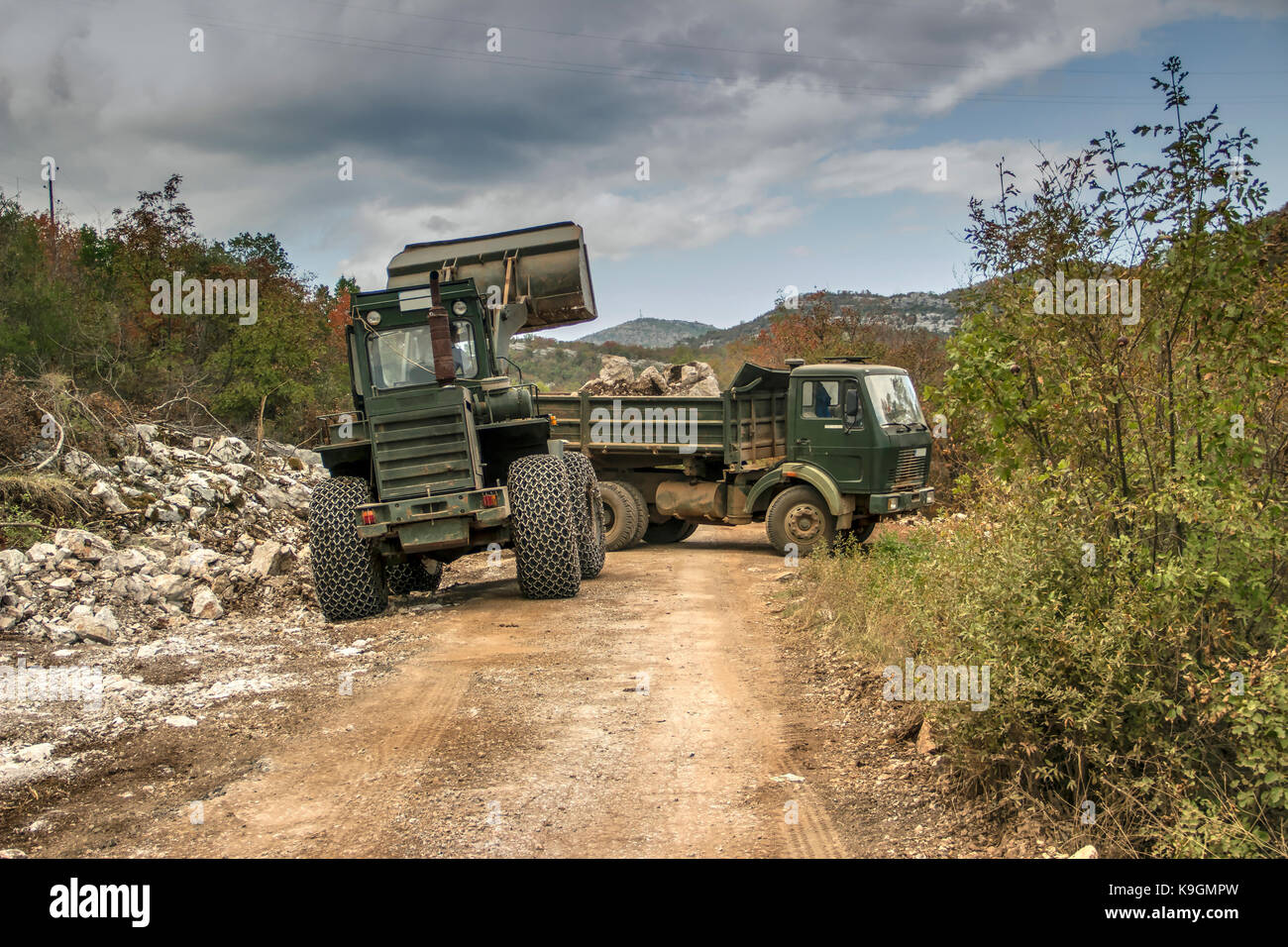 Montenegro - ein Radlader und ein Lkw klare Bergsturz von Felsen von einer Mountain Road Stockfoto