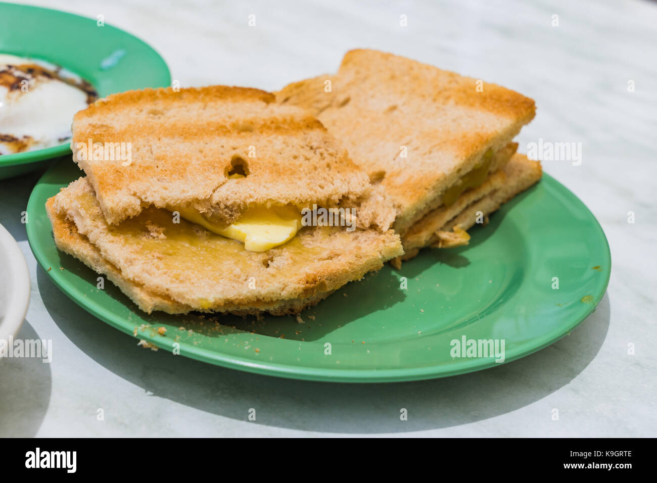 Traditionelle Singapur Frühstück namens Kaya Toast, Brot mit Kokosnuss Marmelade und Halbe gekochte Eier, selektiven Fokus Stockfoto