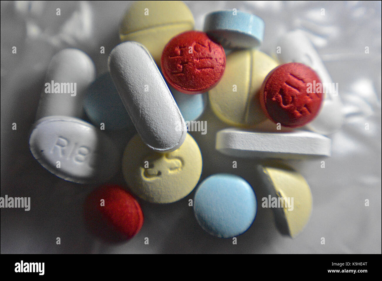 Makroaufnahme bei wenig Licht für eine Handvoll Pillen: Verschreibungspflichtige Schmerzmittel, Anxiolytika, Antidepressiva, Reizmittel abschwellende und ein muskelentspanner Stockfoto