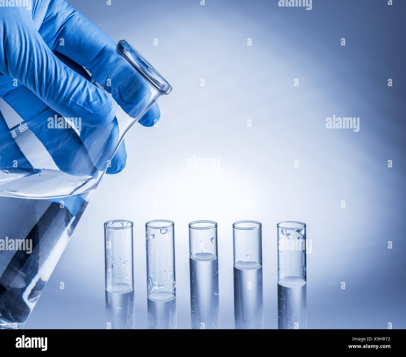 Labor-Becher in der Hand des Analytikers in Kunststoff-Handschuh. Stockfoto