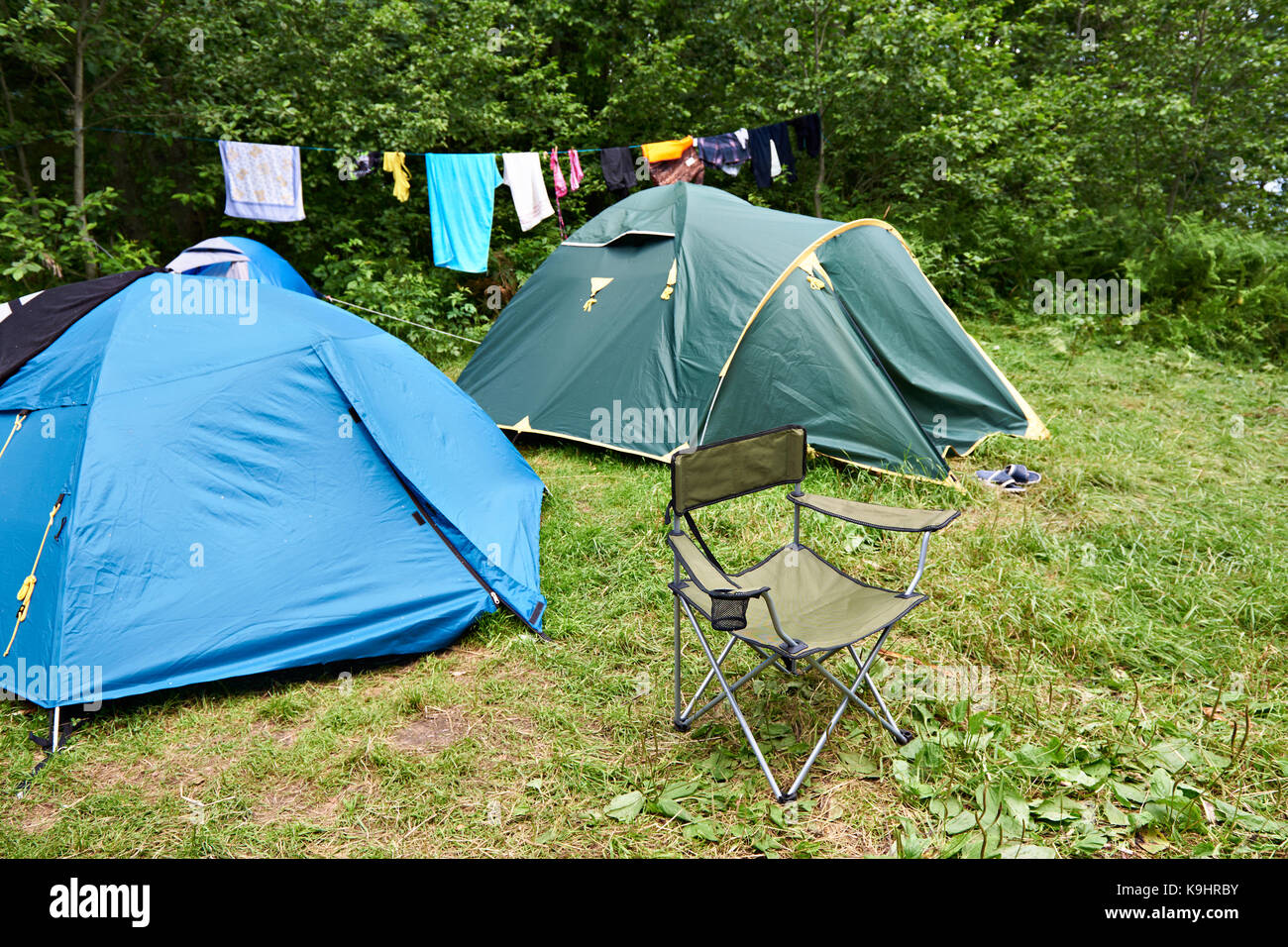 Folding camping Stuhl und Zelt auf der Wiese Stockfoto