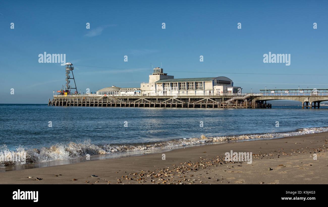 Bournemouth Pier von einem niedrigen Winkel angezeigt, brechenden Wellen an der Küste und einem einsamen Strand Stockfoto