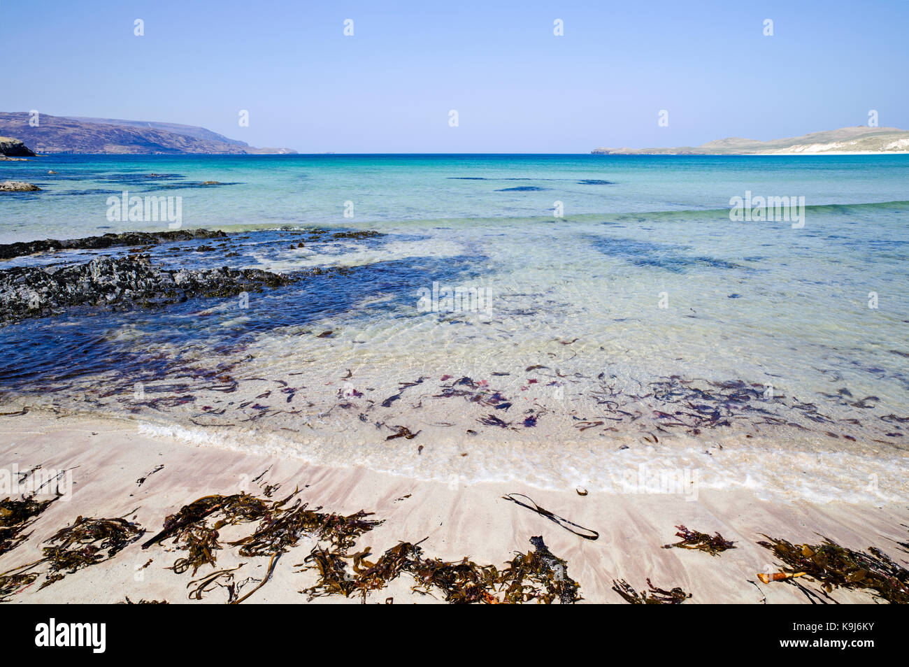 Seetang (Kelp) an den Rand des Wassers von den wunderschönen weißen Sandstrand auf balnakeil Bay, Durness, Sutherland, Schottische Highlands, auf einem ruhigen sonnigen Tag. Stockfoto