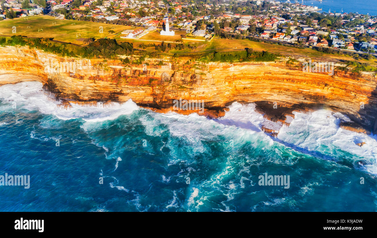 Wave break von endlosen Pazifik ozeanische Wellen schlagen und Erodieren Sandstein rocky Plato des australischen Kontinents um Macquarie Lighthouse in Sydney. Stockfoto