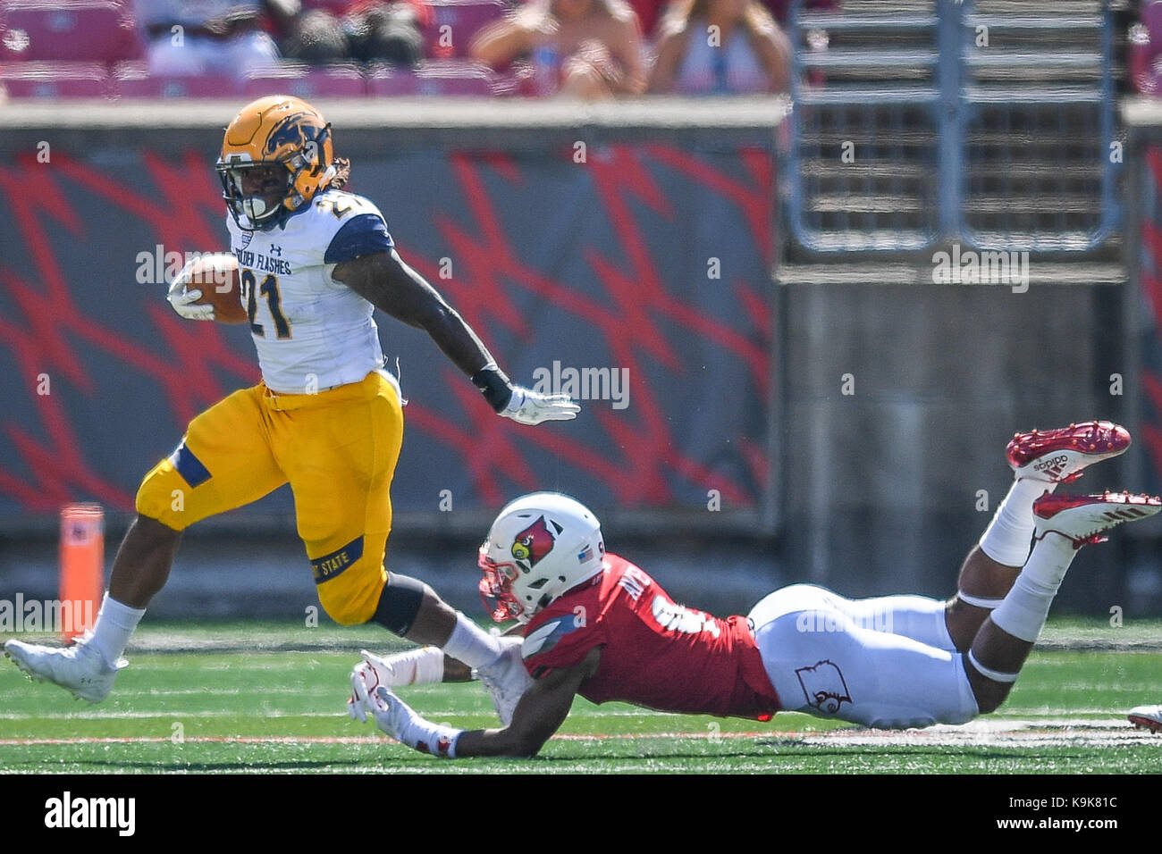 Louisville, Kentucky, USA. 23 Sep, 2017. Kent State Golden blinkt zurück laufen wird Matthews (21) vermeidet die Bekämpfung von Louisville Kardinäle Sicherheit C.J. Avery (9 während des Spiels in Louisville, Kentucky, Samstag, 23. September 2017. Credit: Bryan Woolston/ZUMA Draht/Alamy leben Nachrichten Stockfoto