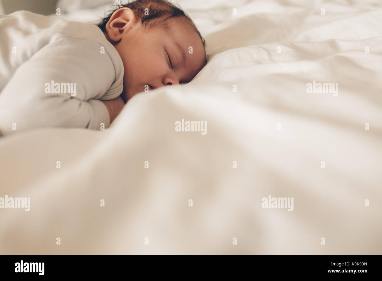 Cute Baby im Bett liegen und schlafen. Little Boy friedlich schlafend im Bett. Stockfoto