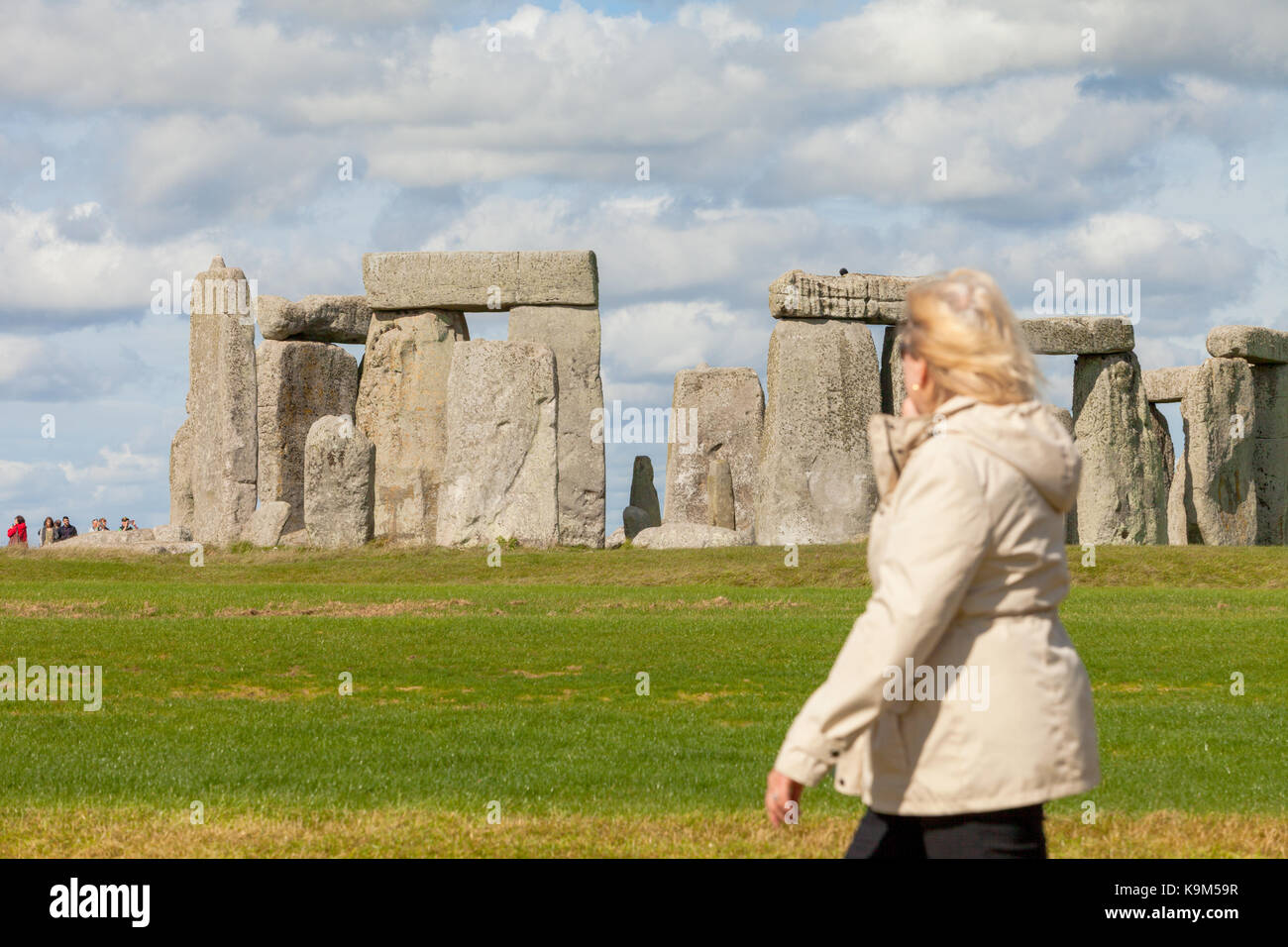 Eine einzelne touristische steht vor Stonehenge Welterbe in Wiltshire, Großbritannien Stockfoto