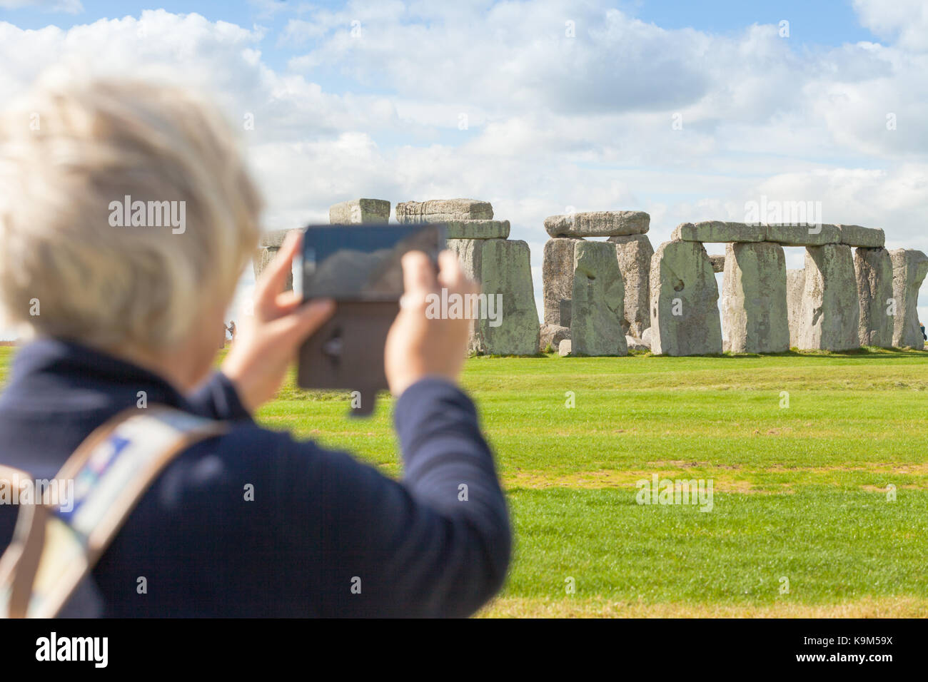 Eine einzelne touristische steht vor Stonehenge Welterbe in Wiltshire, Großbritannien Stockfoto