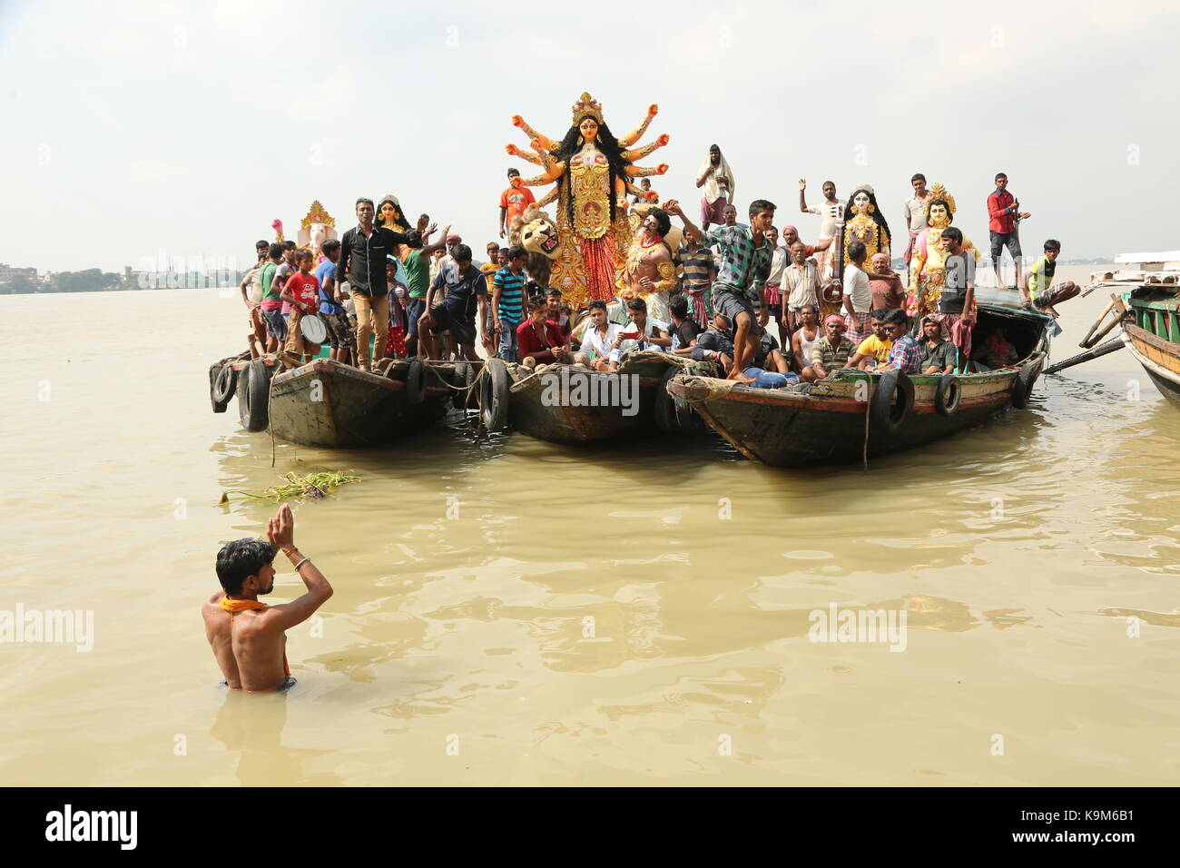 Ein Ton Statue der indisch-hinduistischen Göttin Durga ist von einer Werkstatt in Kumartoli, Dorf, das Idol der Filmemacher transportiert, mit dem Boot auf dem Fluss Ganges Stockfoto