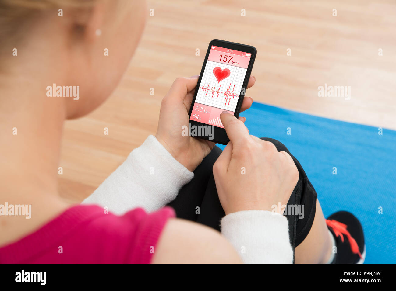 In der Nähe von Frau mit Mobiltelefon mit Pulsfrequenz Stockfoto