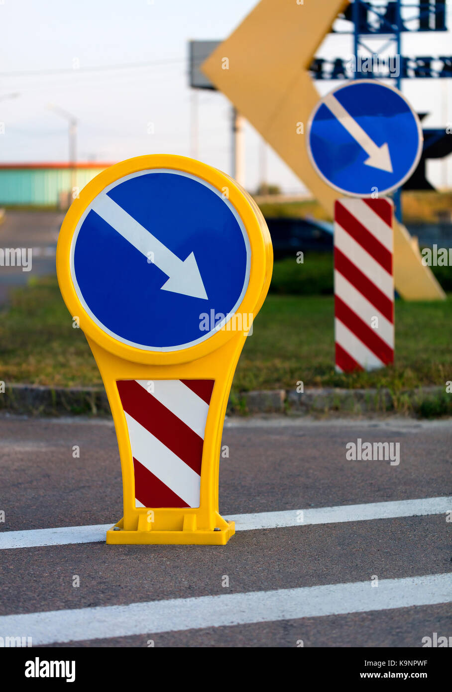 Runde Helle gelb-blauen Schild Umweg auf der rechten Seite mit weiß-rote diagonale Warnung Streifen auf der Straße markieren Stockfoto